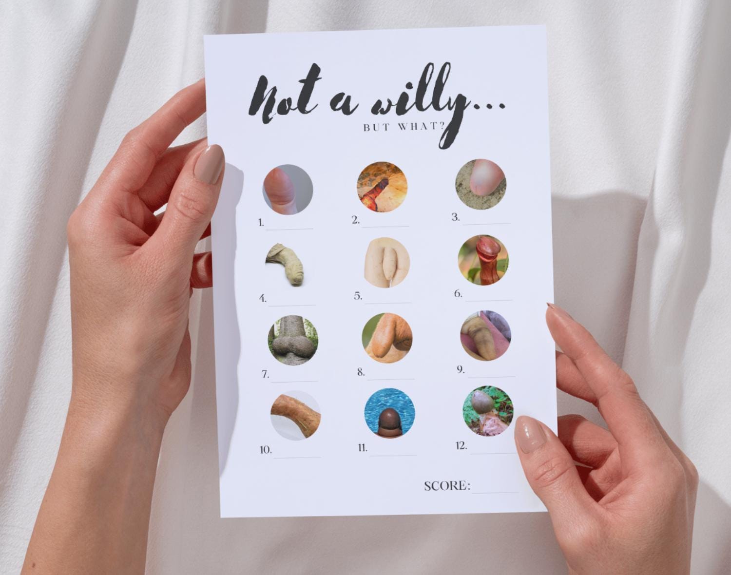 Person holding a hen do party game: 'Not a willy... but what?' against a white background.