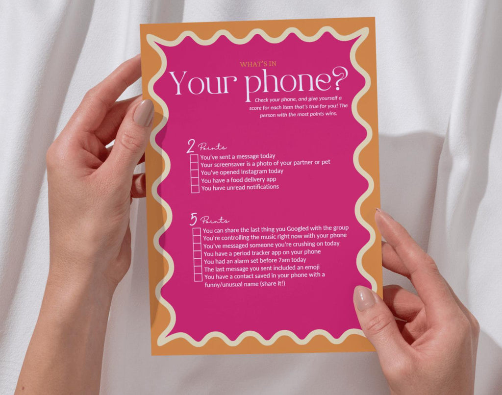 One 'What's on your phone' bridal shower game card held by two hands against a white background.
