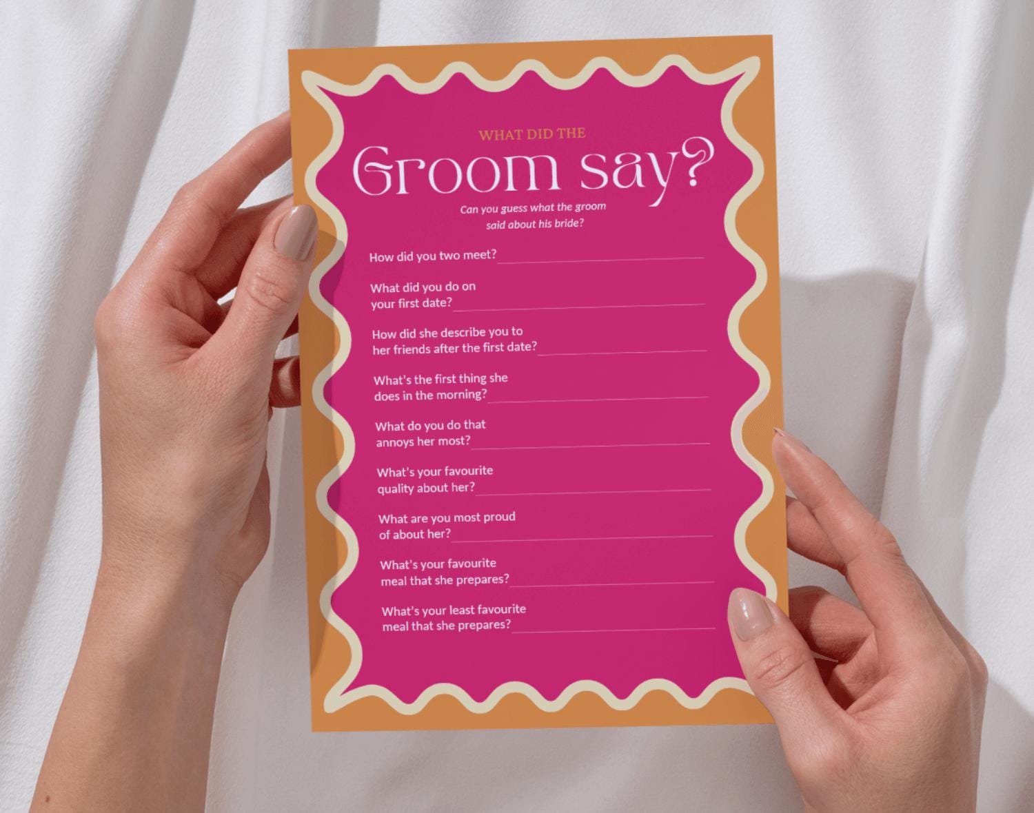 One 'What did the Groom say?' bachelorette party game held by two hands against a white background.