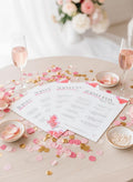 Fanned out Bridal Shower Family Feud party game cards on a table with bubbly and confetti.