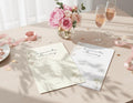 Two 'favourite memory with the bride' cards, one white and one with cream background, on a table with flowers and ribbons.
