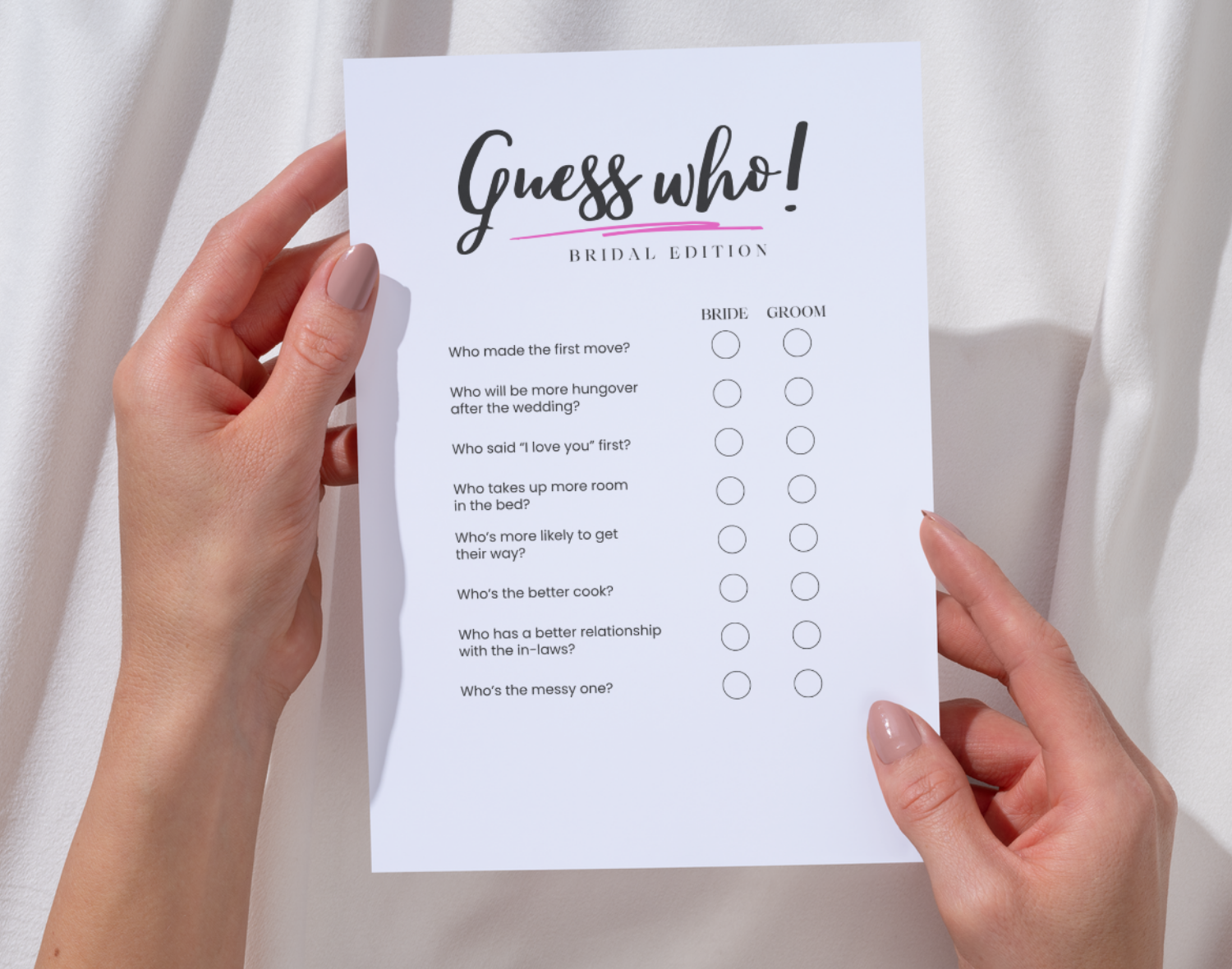 Two hands hold a 'Guess who' bachelorette party game sheet against a white background.