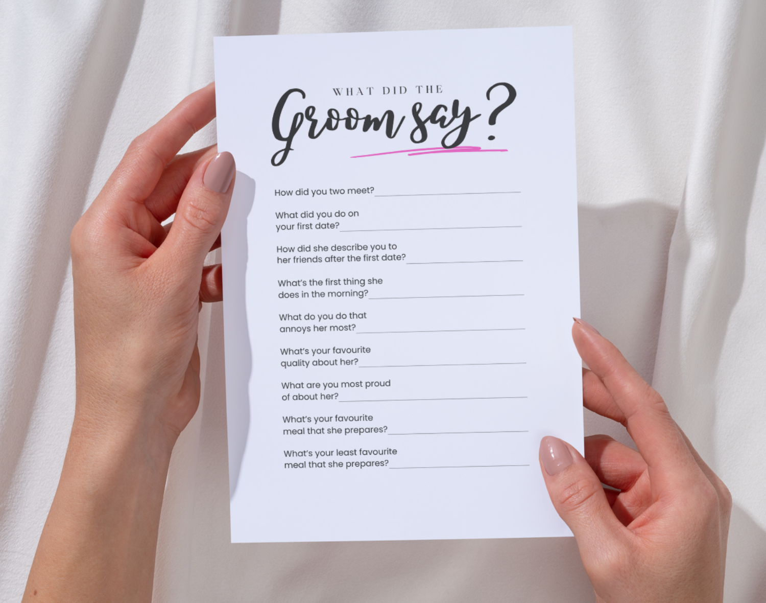 Two hands hold a hen do game sheet titled 'What did the Groom say?' against a white background.